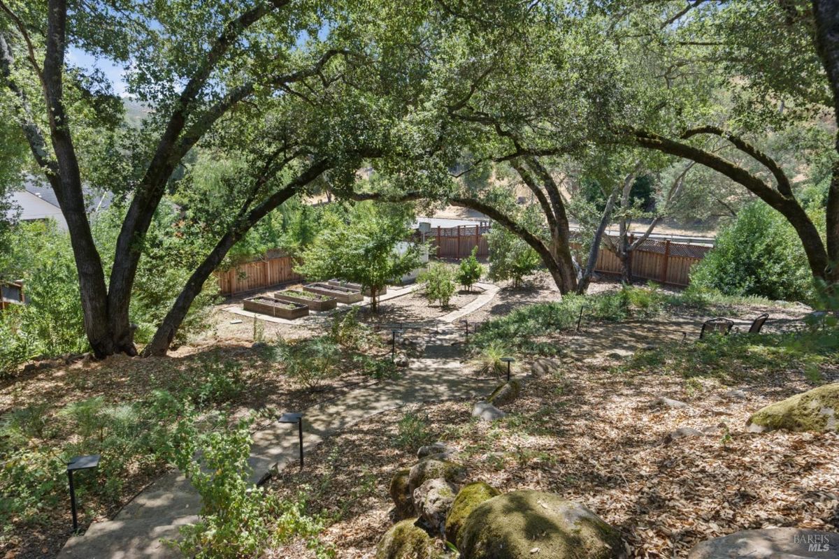 The property features a terraced garden with raised beds and mature trees.