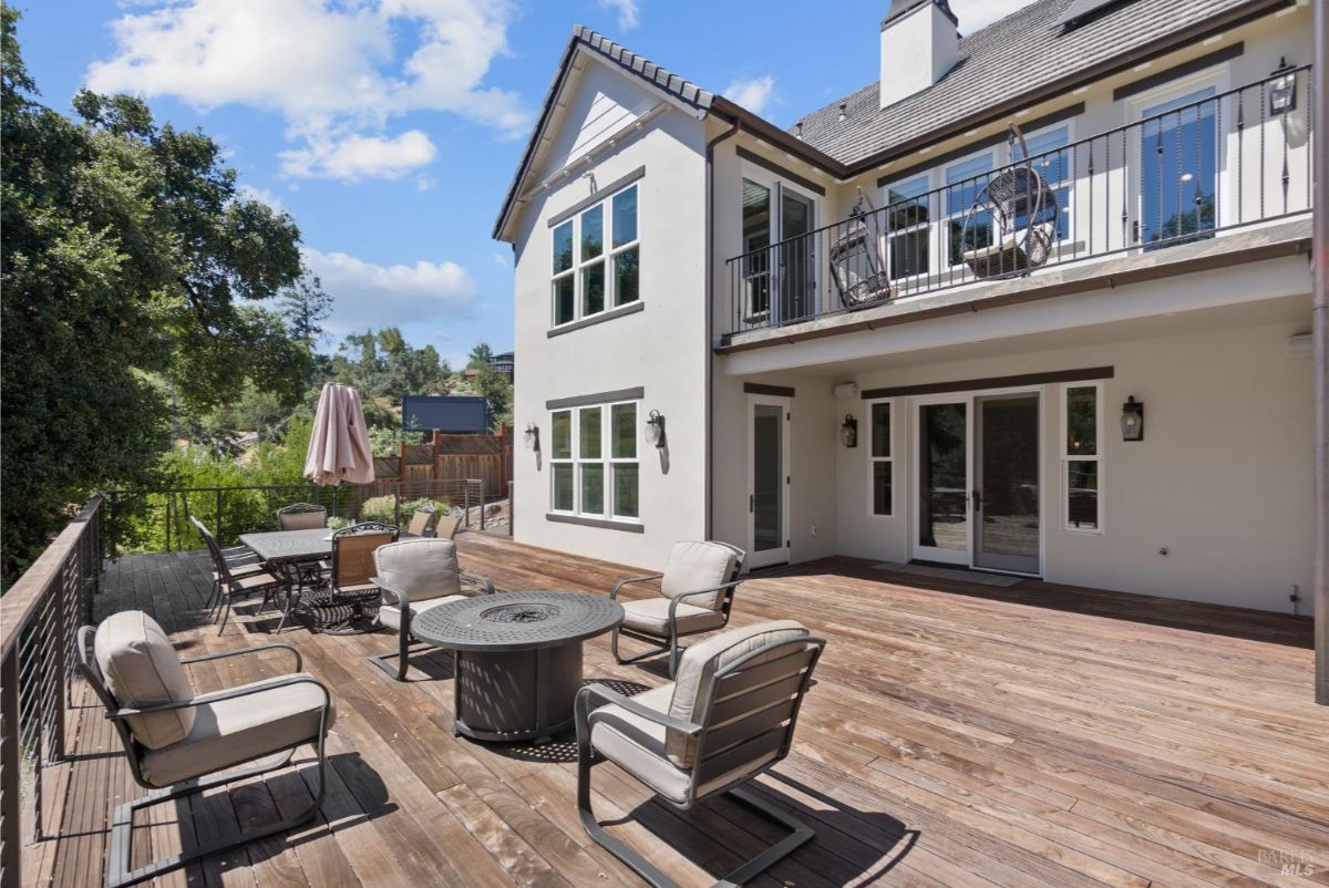 The home features a large deck with a seating area and a fire pit.