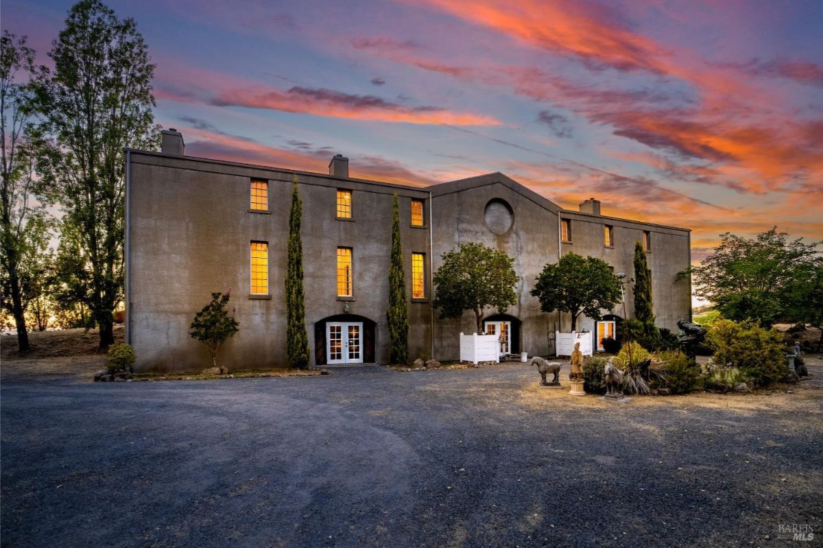 The estate’s exterior illuminated at dusk with a dramatic sky, showcasing its symmetrical design.