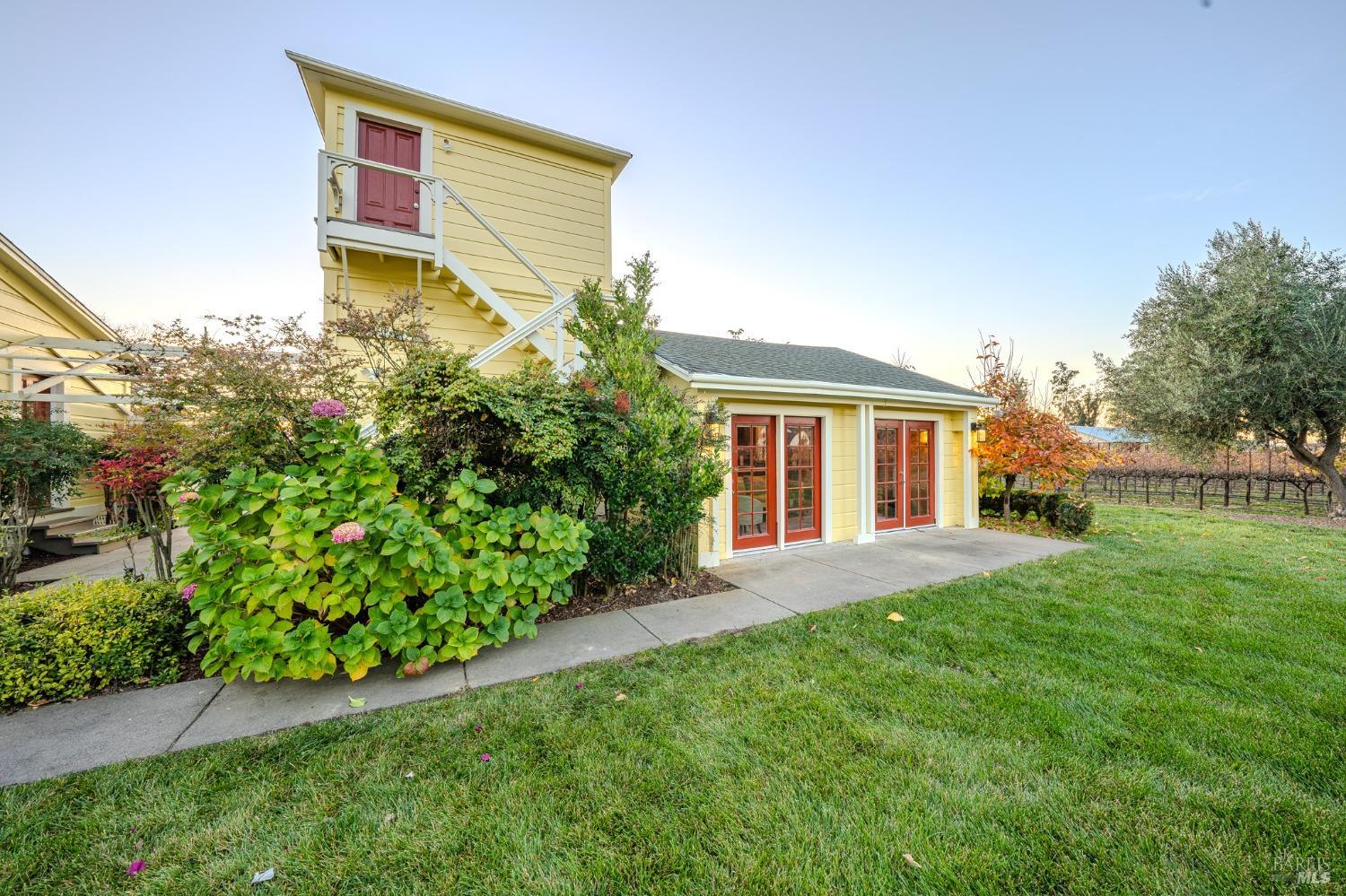 This charming yellow guest house, nestled amidst a picturesque vineyard, features a private patio with French doors, offering a tranquil retreat. The main house boasts a balcony overlooking the idyllic landscape, providing a perfect vantage point to enjoy the surrounding beauty.