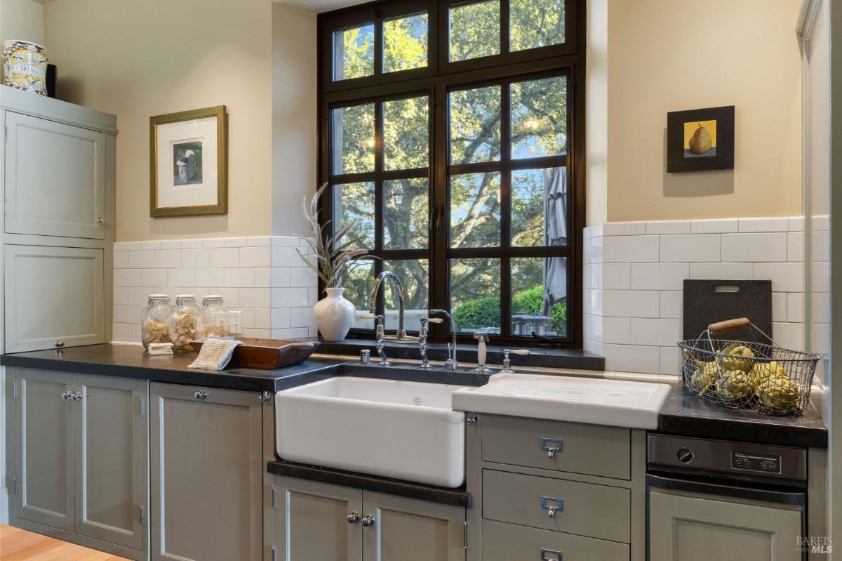 Close-up of the sink area with a view outside, emphasizing natural light and counter decorations.