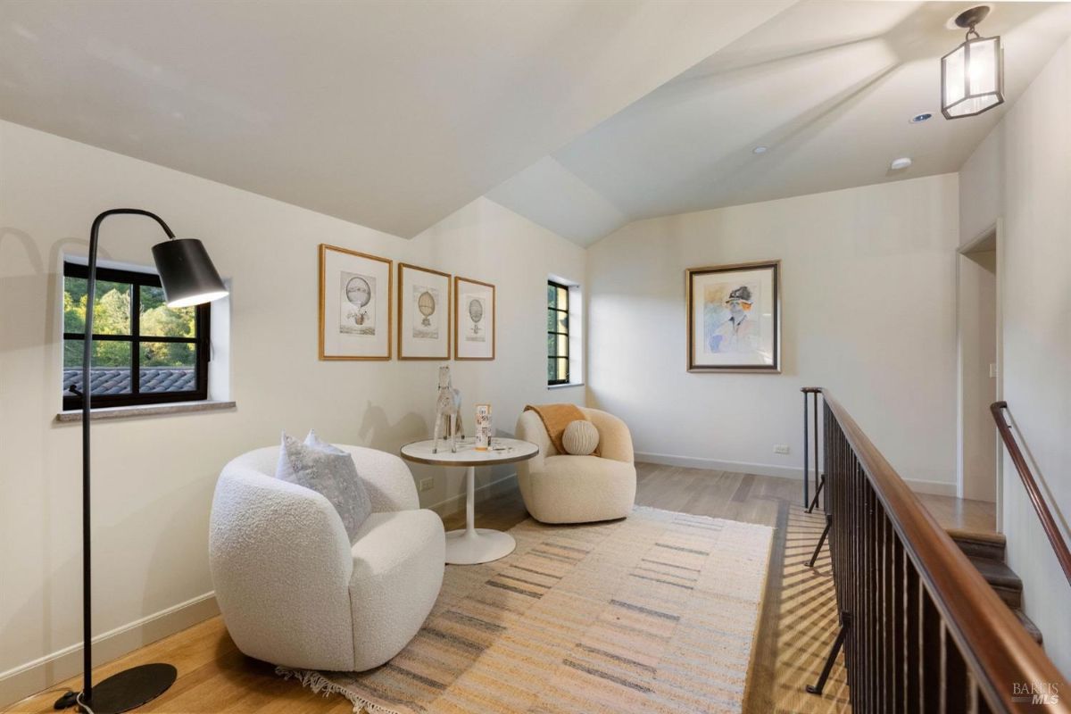 Cozy seating area with armchairs, a small table, and decorative art on the walls.