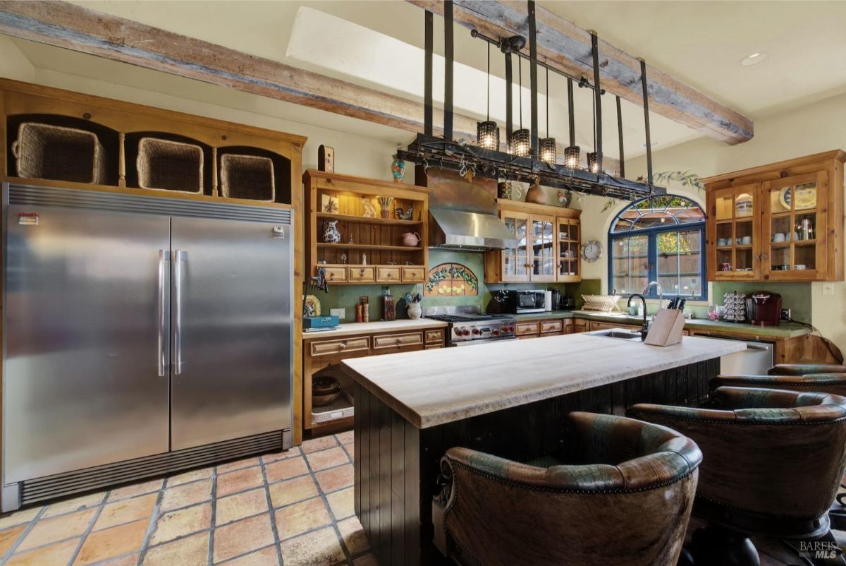 Stainless steel double-door refrigerator is paired with wooden cabinets and decorative elements above the stove.