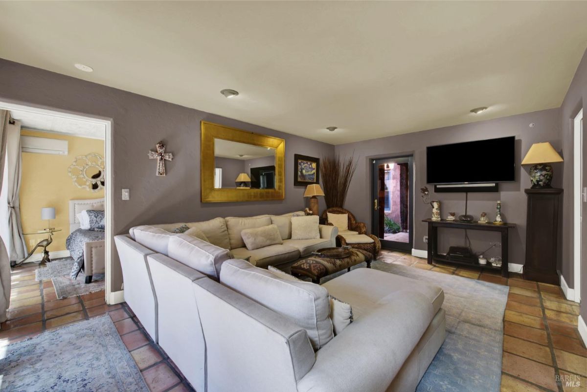 Living room with a large sectional sofa, wall-mounted television, and cozy decor.