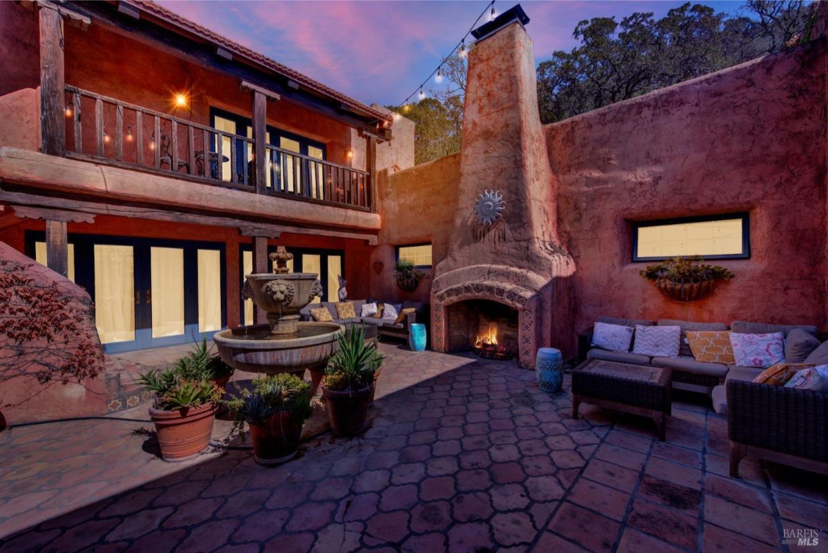 The courtyard has a fountain, a fireplace, seating areas, and a brick-paved floor.