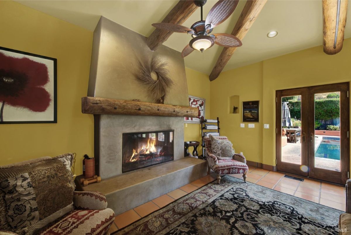 Elegant fireplace with a rustic wooden mantle in a warm, inviting setting.