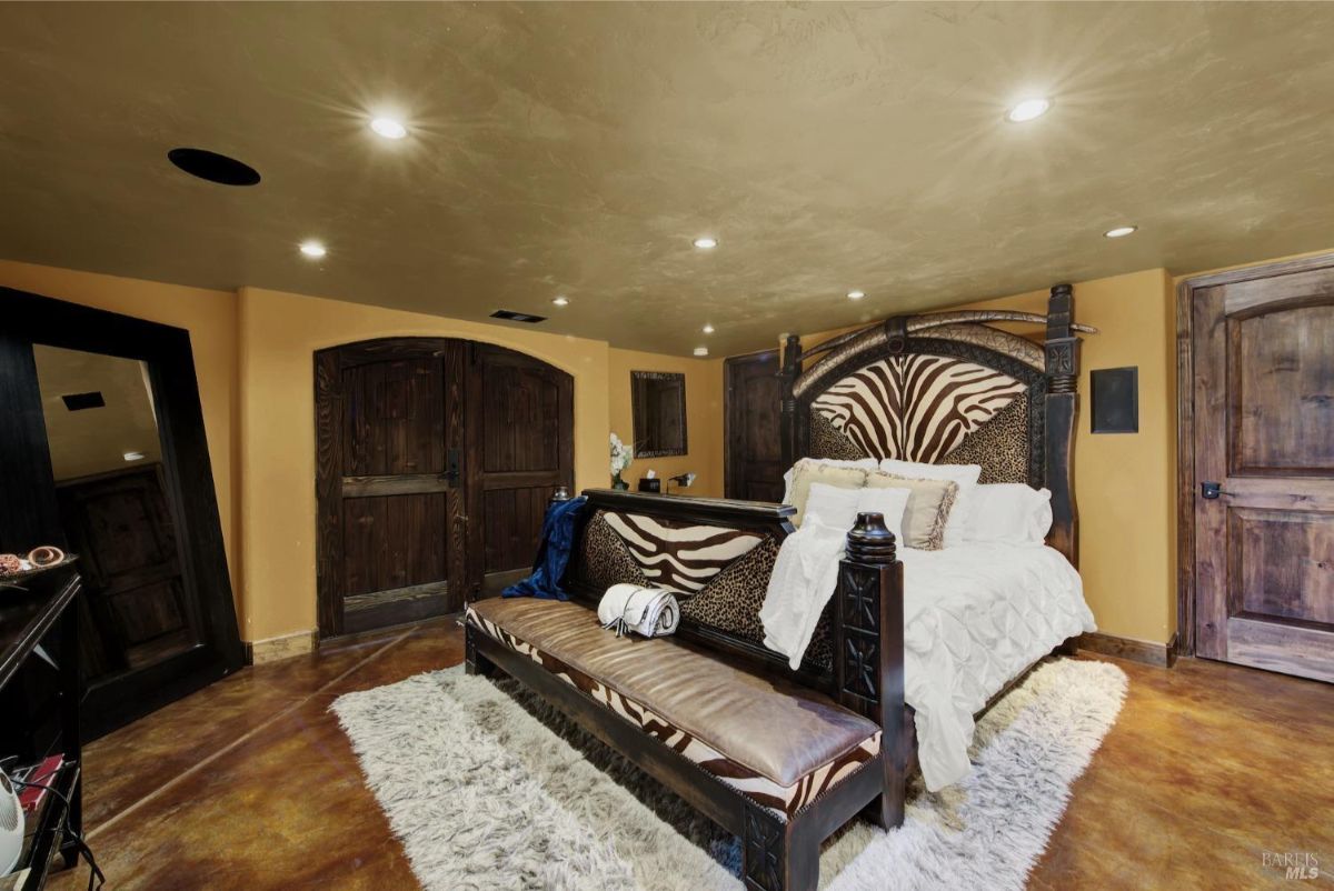 Bedroom showcases warm earth tones, a unique zebra-print headboard, and a cozy atmosphere with dimmed lighting.