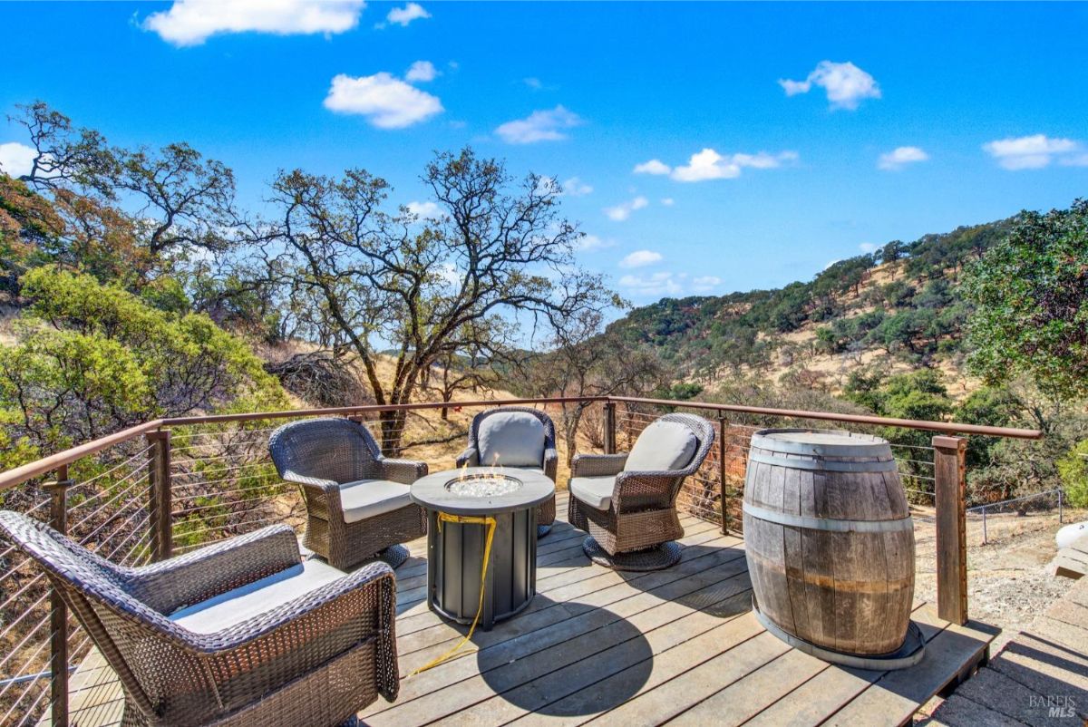 The deck has a fire pit, seating, and a barrel.