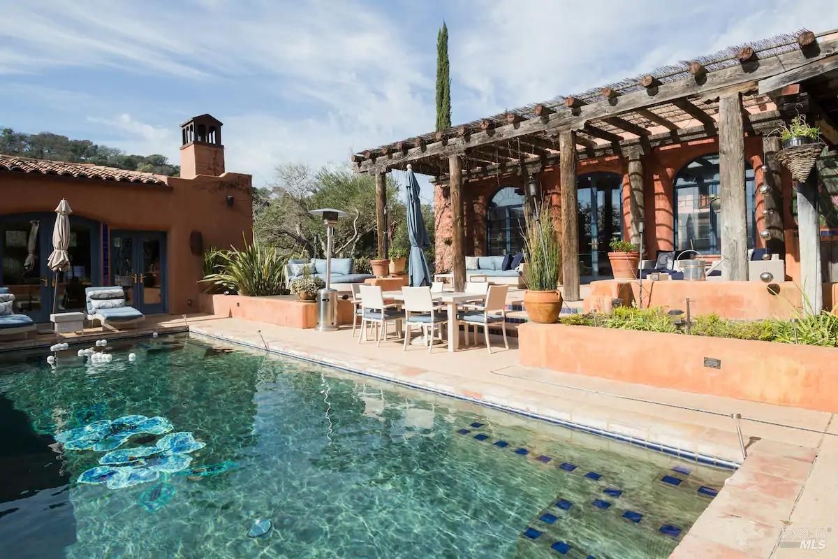 The pool area has a large rectangular pool, a fountain, and a patio with seating.