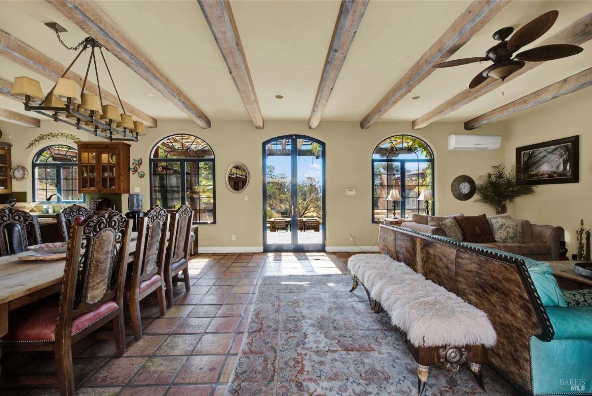 Expansive dining area with detailed wood furniture and access to an outdoor courtyard.