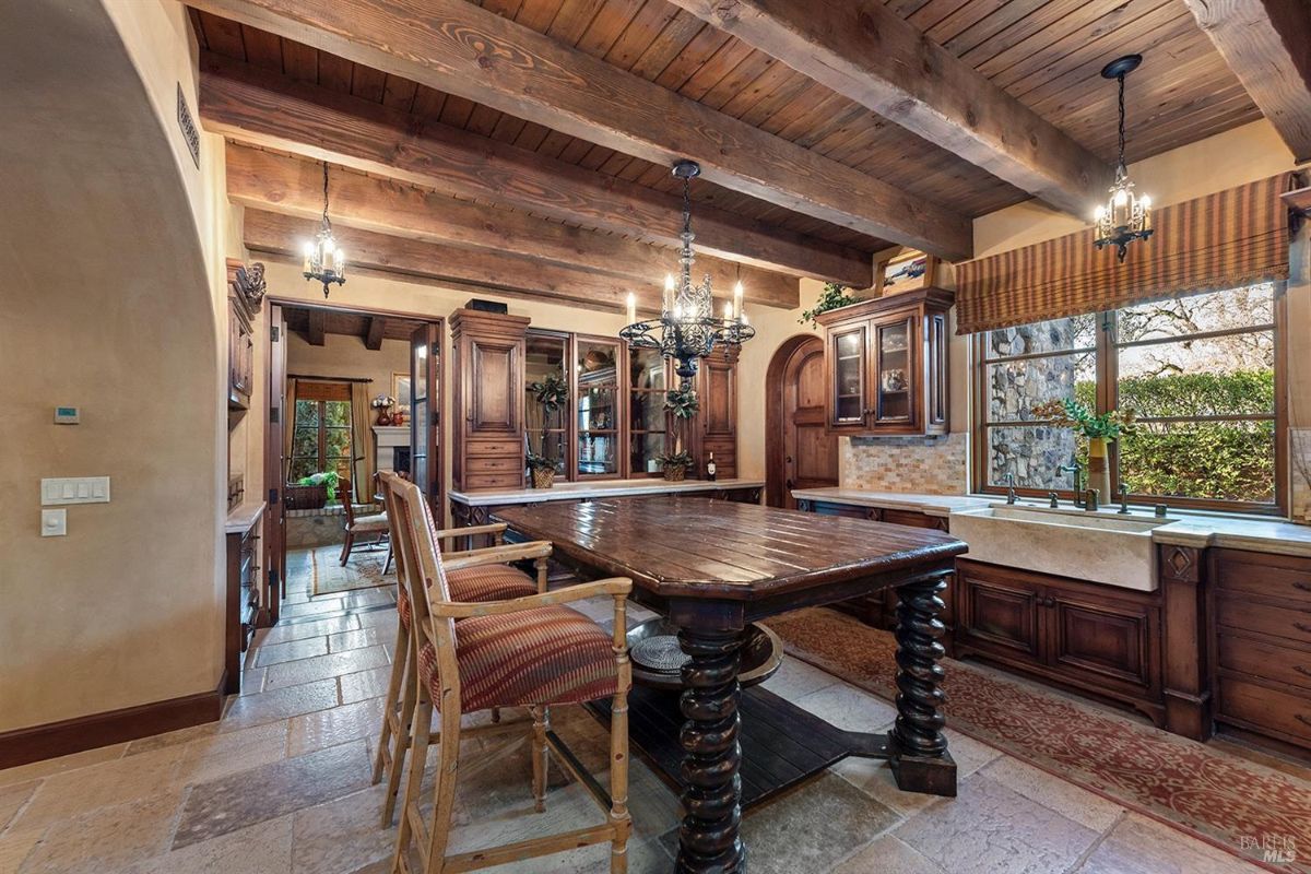  Another perspective of the kitchen showing the same features, with a focus on the central island and surrounding cabinetry. A window provides natural light.