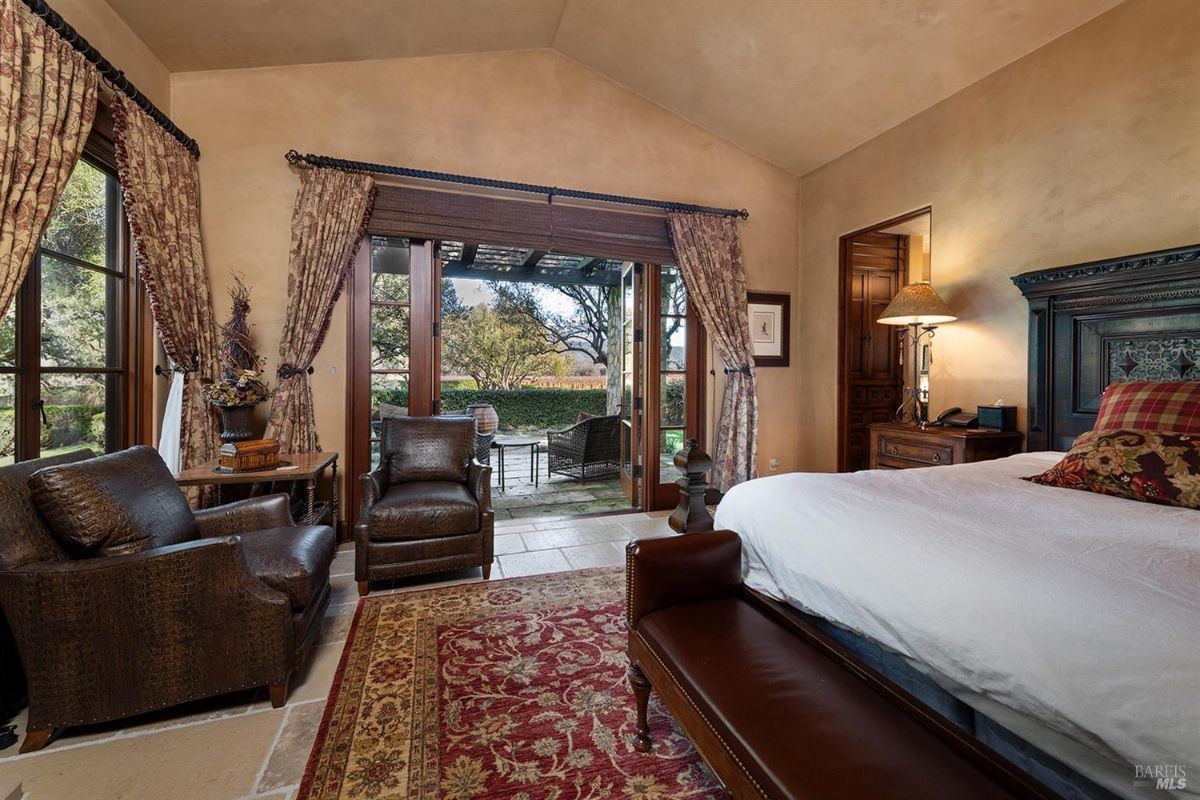 A closer view of the same bedroom showing seating near the glass doors leading to the patio. 