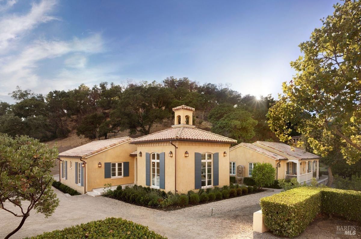 Exterior view of the house situated on a hillside with landscaping