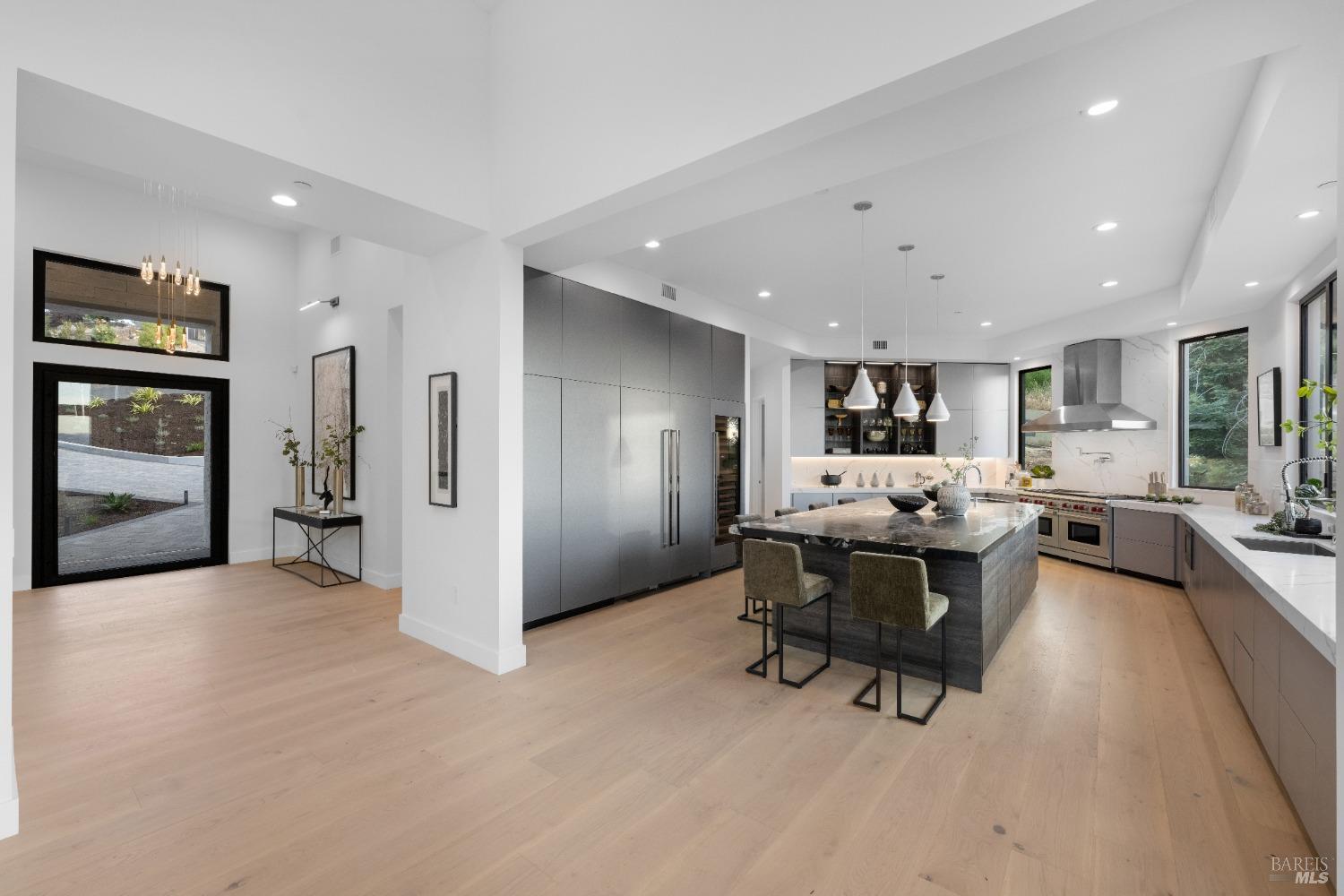 Spacious open kitchen with adjacent entryway and floor-to-ceiling cabinetry.