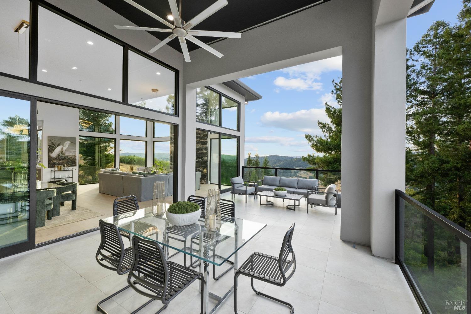 An expansive outdoor dining and seating area with large glass windows connecting to the interior.