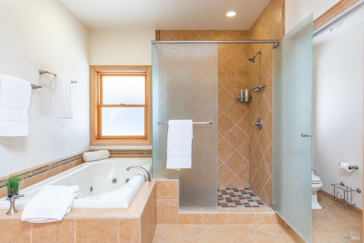 Bathroom with a separate glass-enclosed shower and a soaking tub.