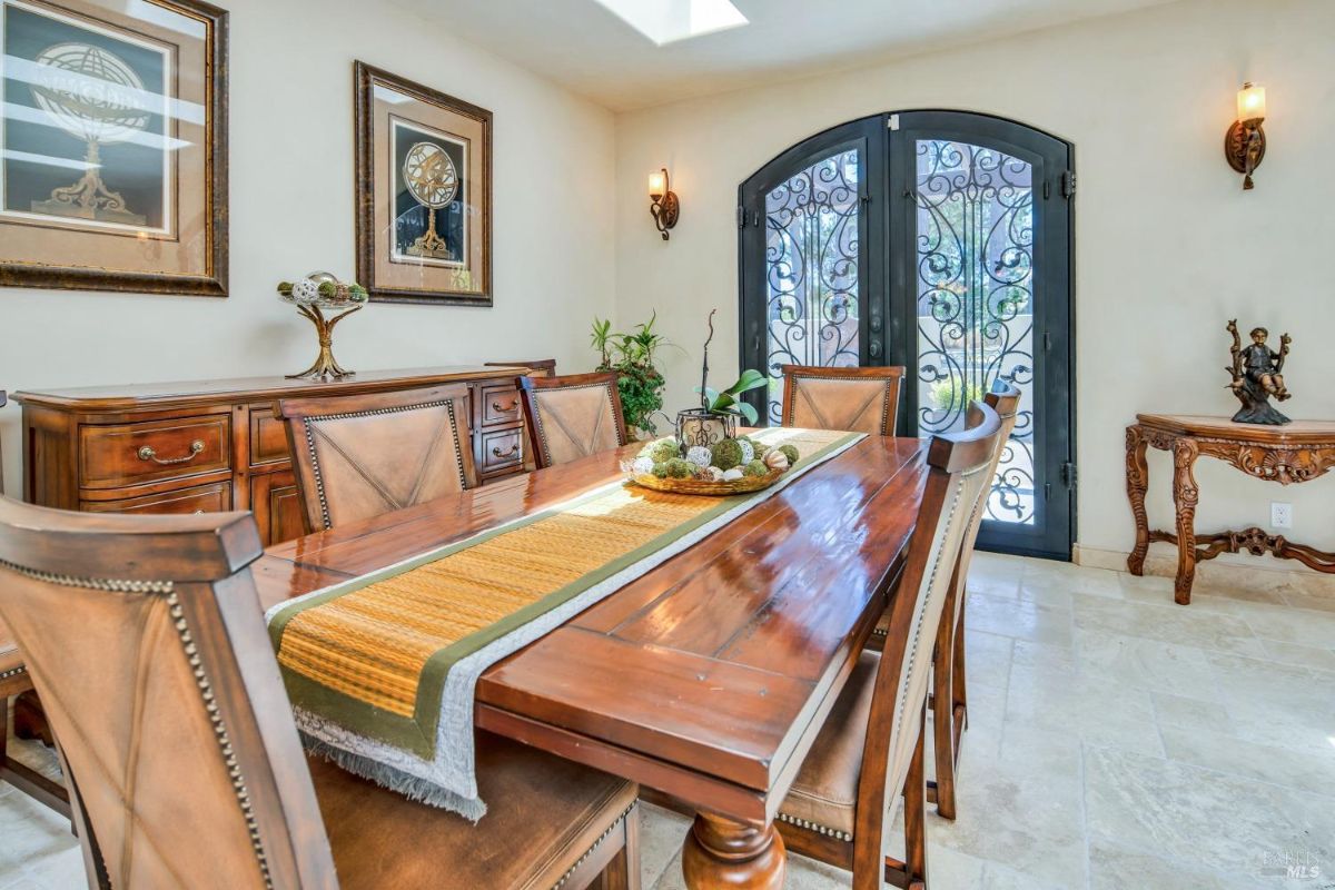 Dining room features a large wooden table with six chairs, a sideboard, and two framed artworks.