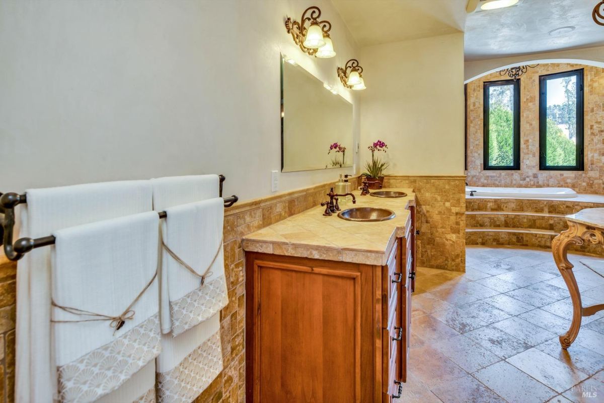 The bathroom features a double sink vanity with a mirror, a bathtub, and a towel rack.