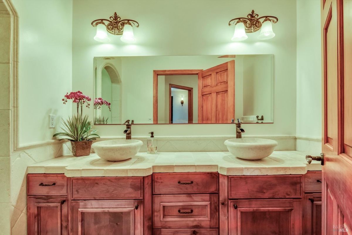 The bathroom features a double sink vanity with wooden cabinets and a mirror.