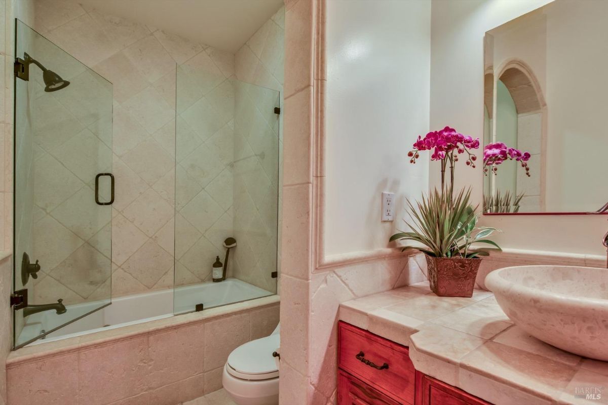 The bathroom features a bathtub, a toilet, a sink, and a mirror.