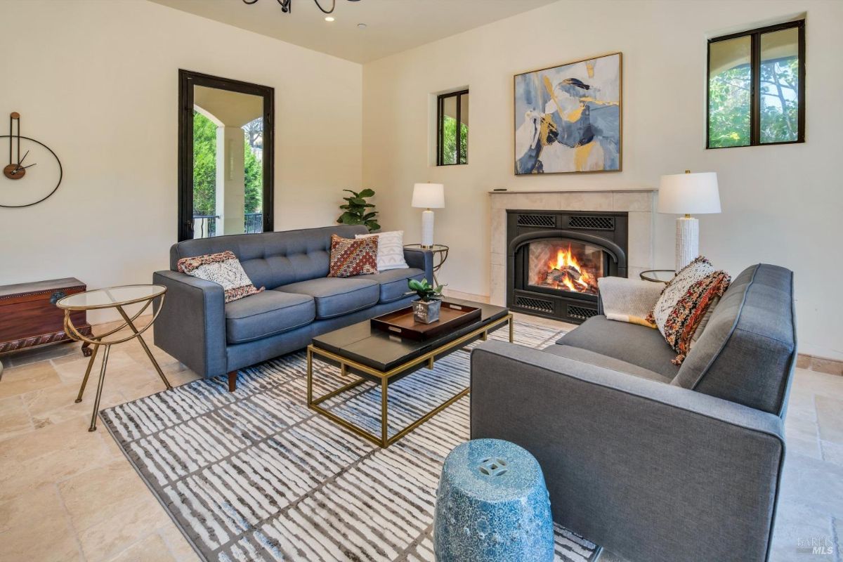 Living room with modern furniture, a fireplace, and abstract wall art.