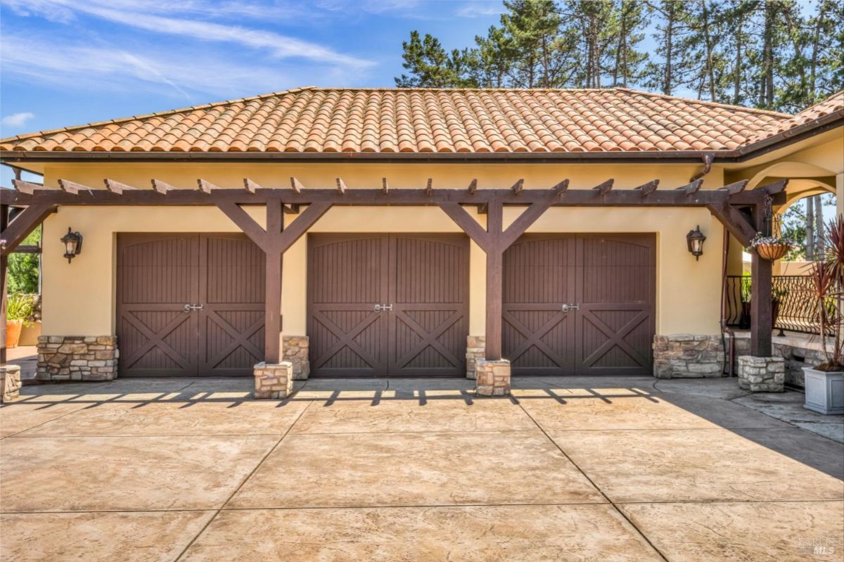 The home features a three-car garage with a pergola overhead.