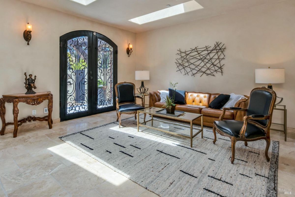 Bright lounge area with leather seating, wrought-iron double doors, and contemporary decor.