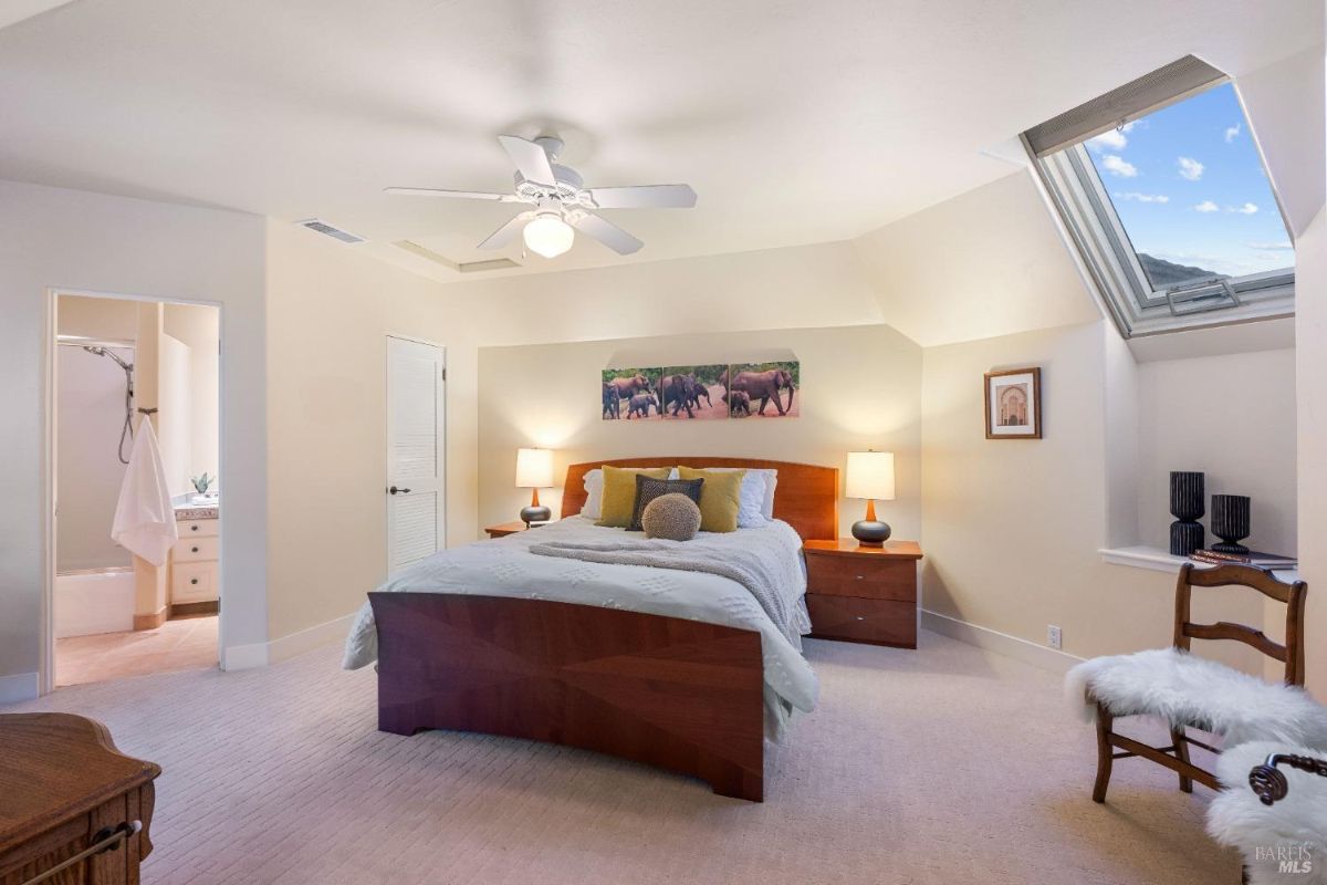 Bedroom with a skylight, neutral tones, and an en-suite bathroom.