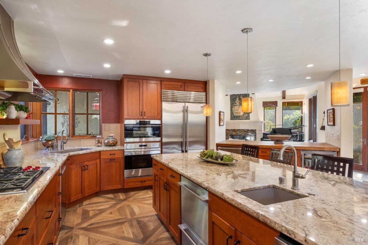 Open-concept kitchen with a large island, double ovens, and pendant lighting connecting to the living area.