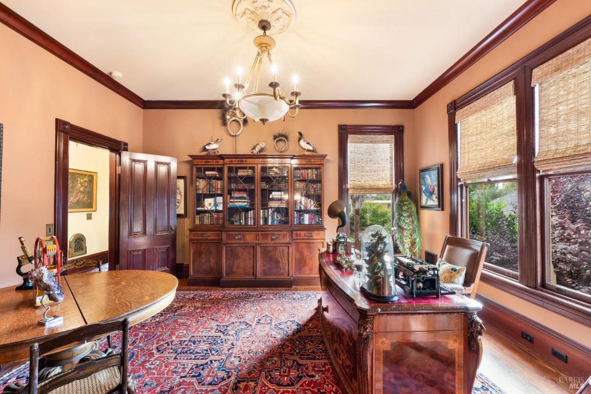 Office with a large desk, wooden furniture, and detailed rugs.