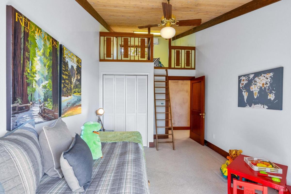 Bedroom with a loft area accessible by a ladder.