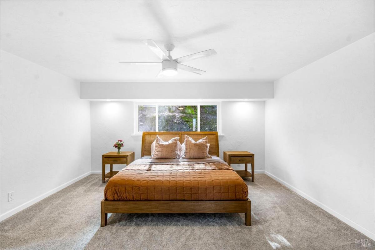 Bedroom with a window above the bed and side tables on both sides.