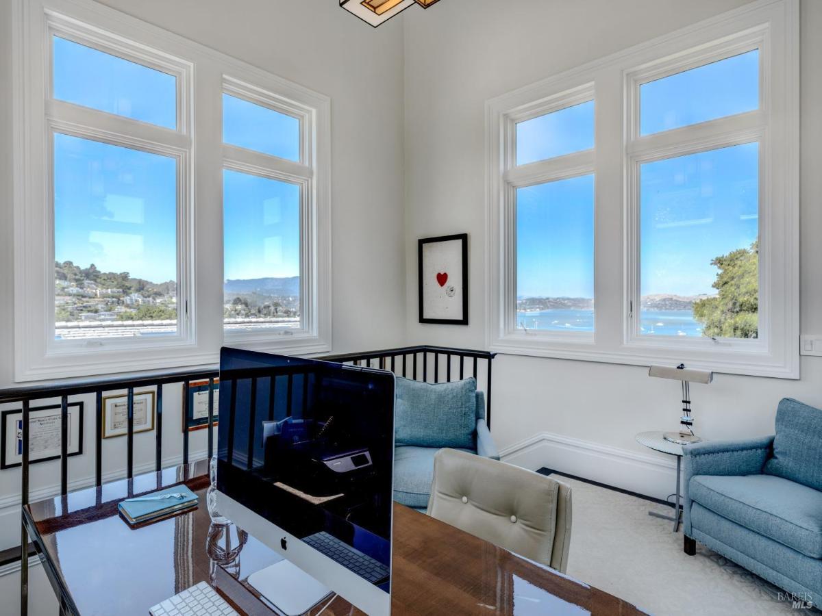 Home office with large windows overlooking a water view.