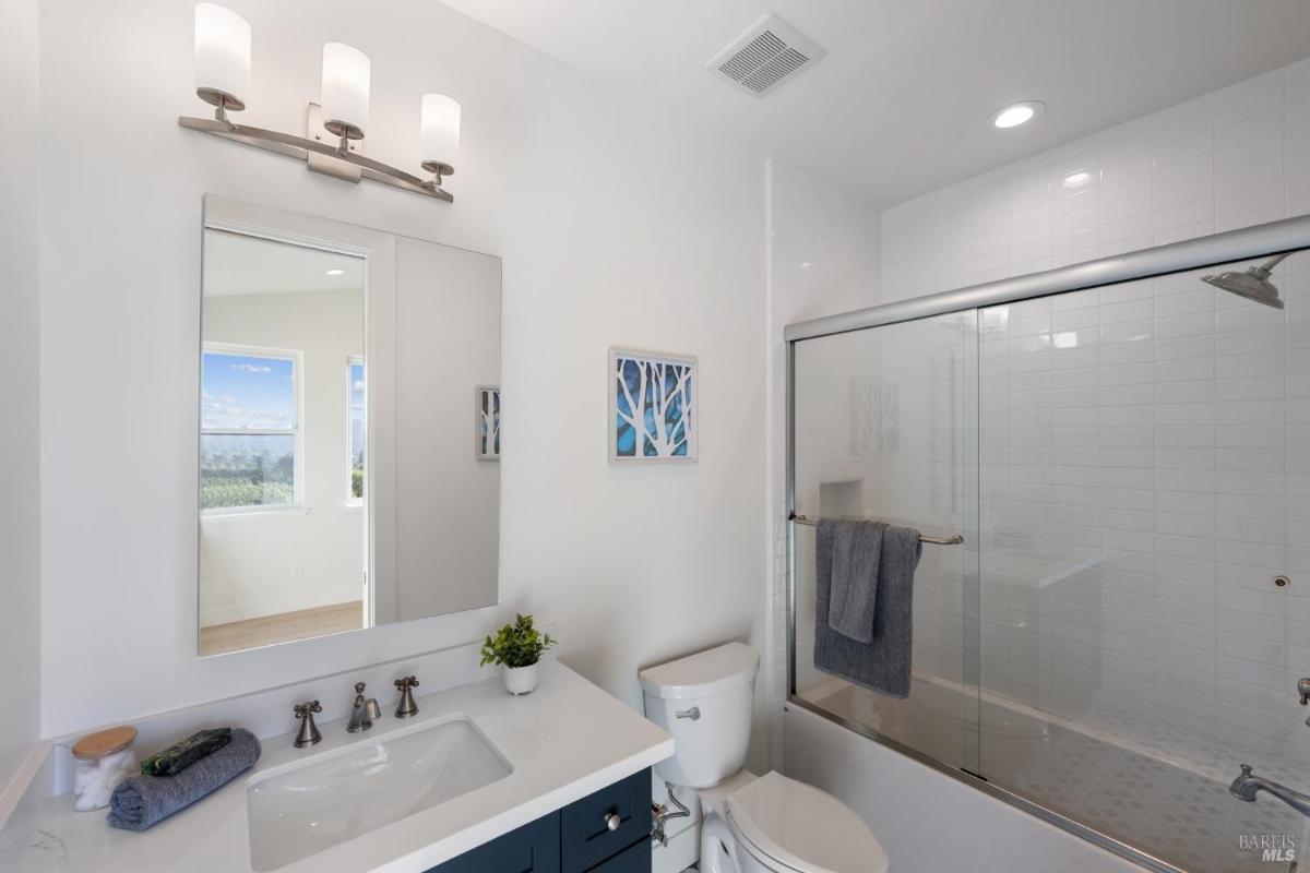 Bathroom with a single sink, toilet, and a shower with glass doors.