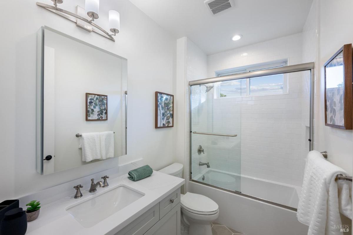 Bathroom with a single sink, toilet, and a tiled shower area.