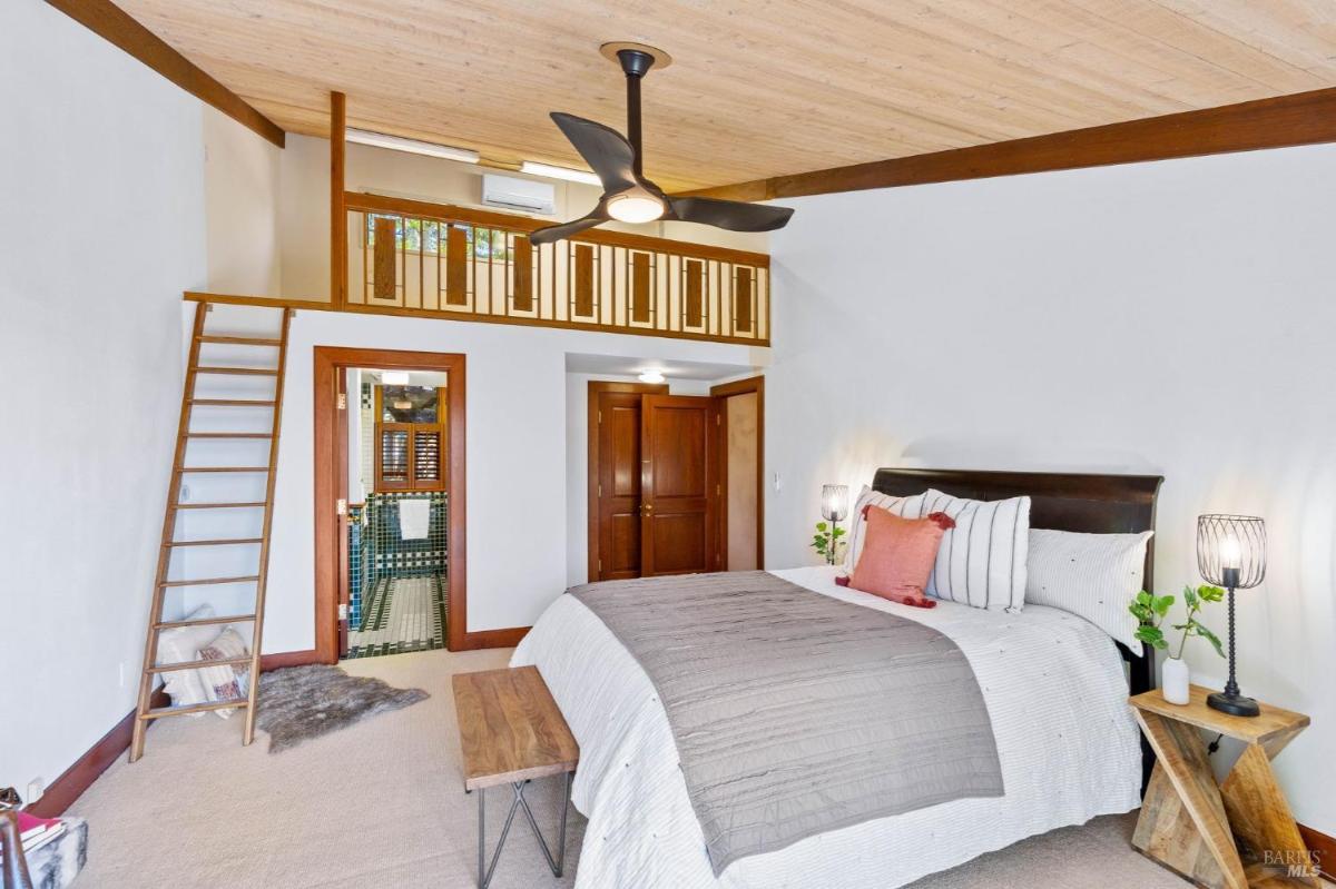 Bedroom with a loft area accessible by a ladder.