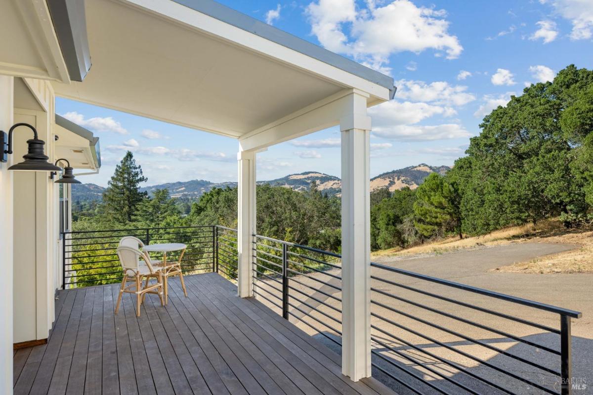 Balcony with seating and views of surrounding hills.