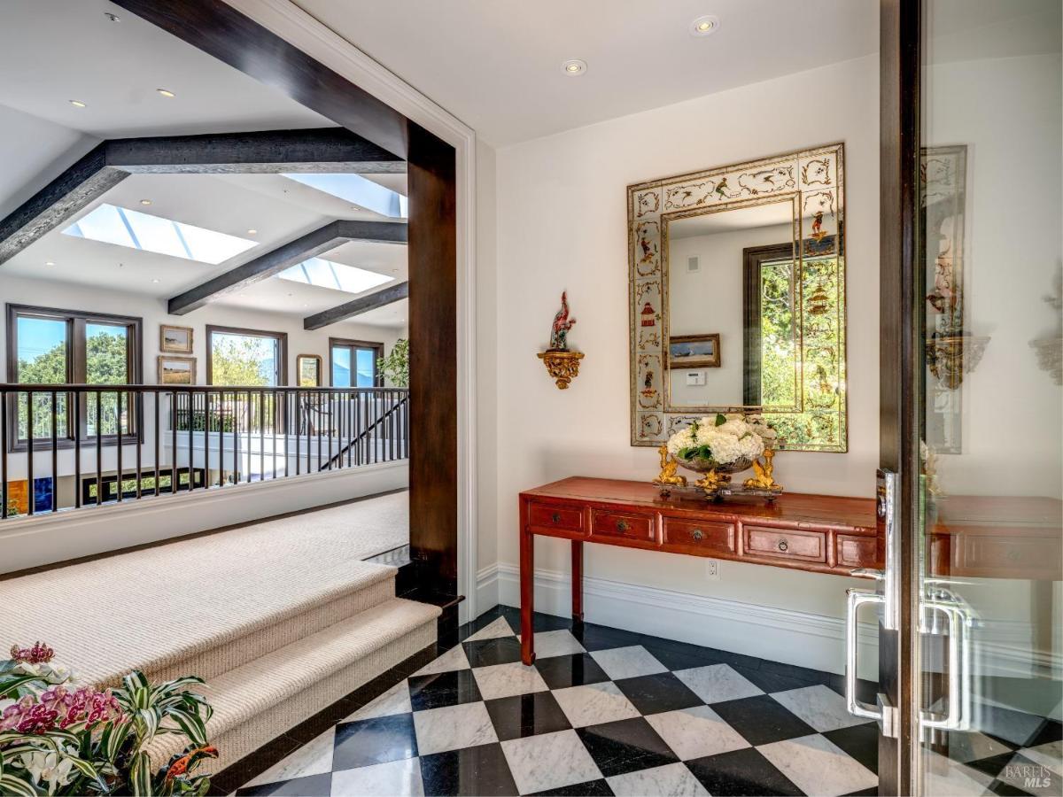 Entryway with a checkered floor, a red console table, and a mirror.