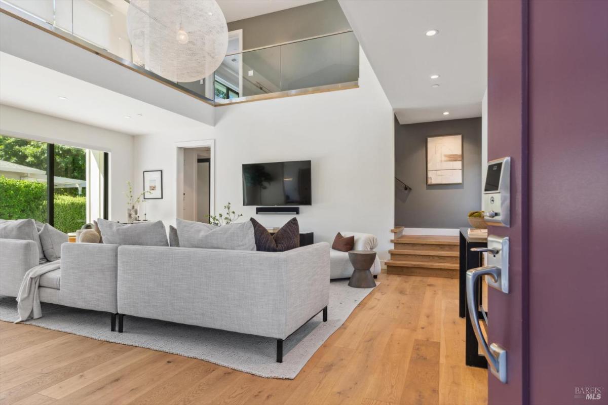 Open living room with a sectional sofa and stairs leading to the upper level.