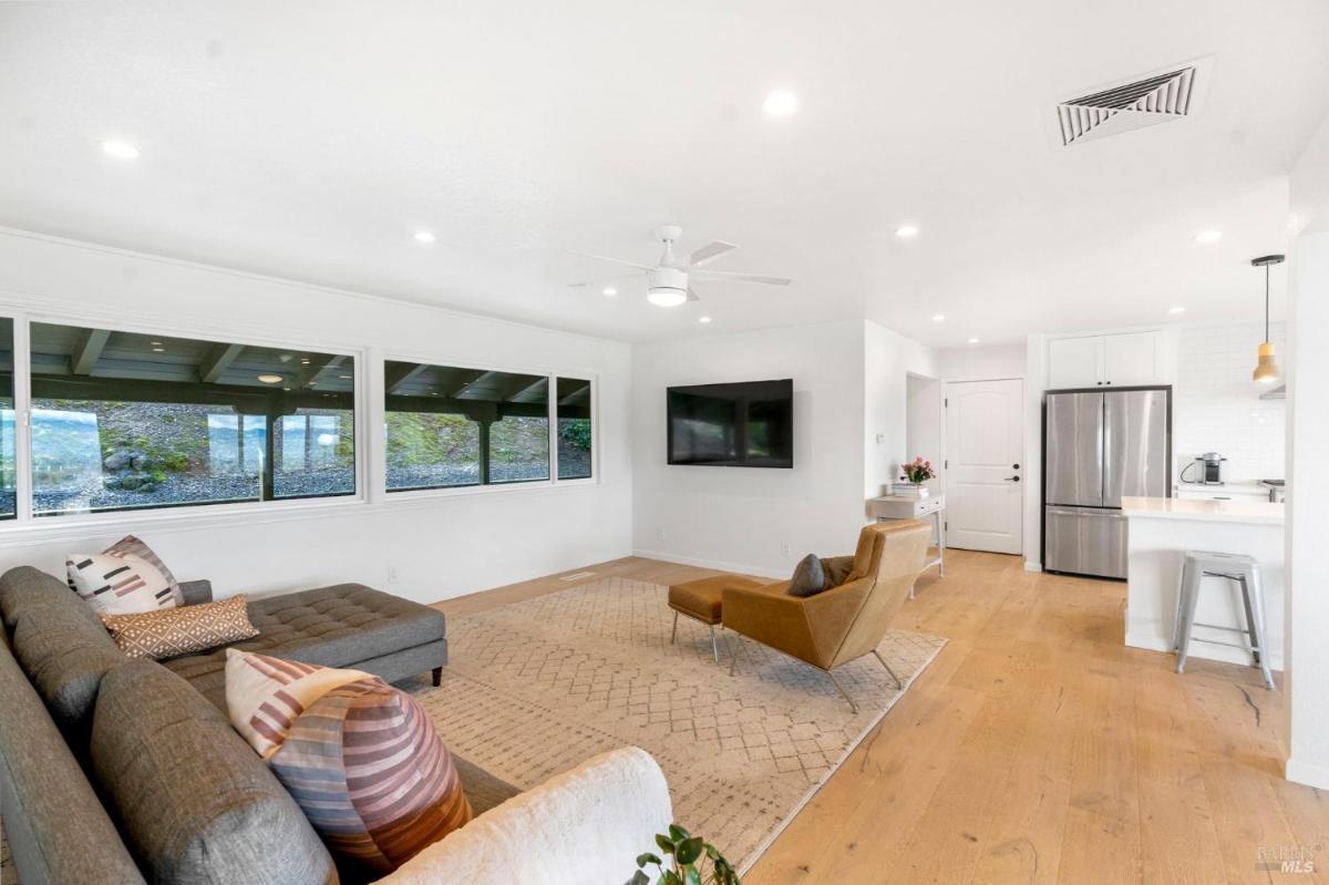 Living room with large windows and a mounted TV.