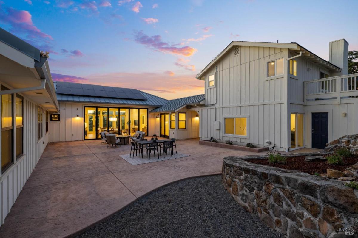 Outdoor patio with seating near the house at sunset.