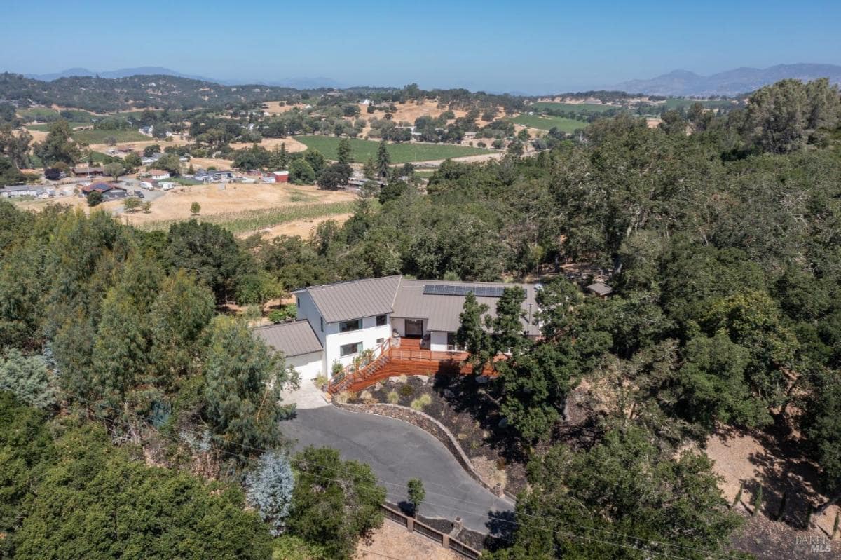 Aerial view of a house with a pool and landscaped property.