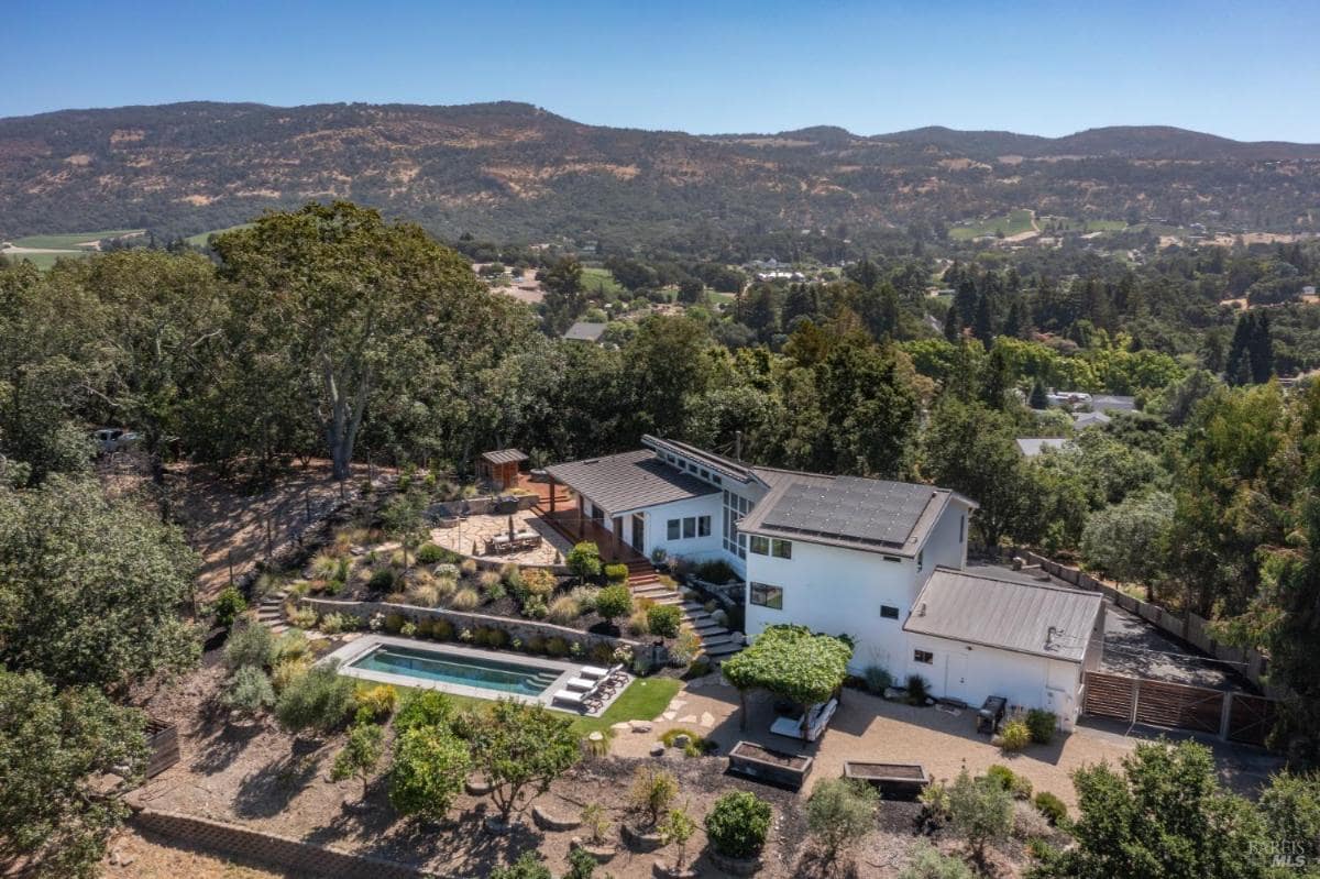 Aerial view of a house with a pool and landscaped property.