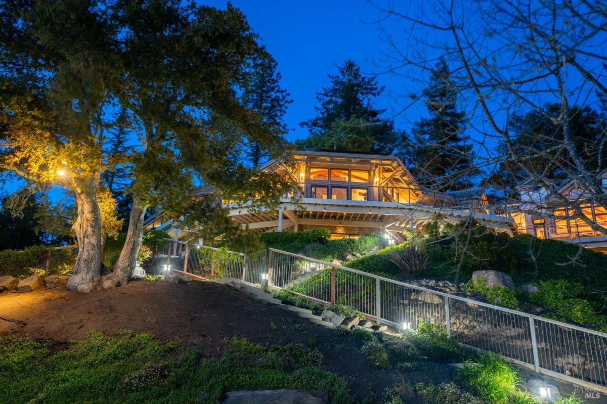 Home exterior with a lit path leading to the house at night.