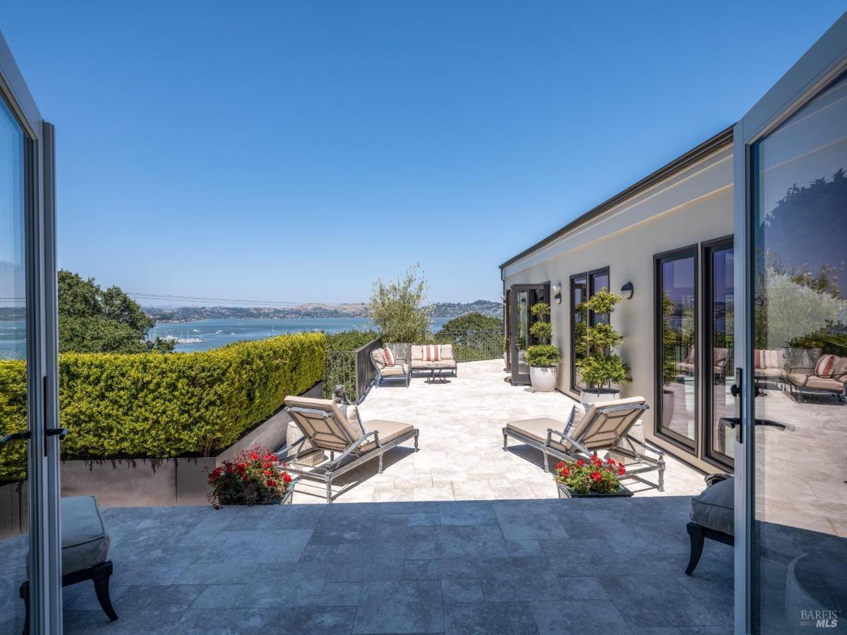 A terrace with lounge chairs and a view of the water.