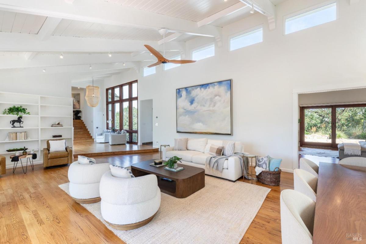 An open-concept living room with exposed beams and high ceilings.