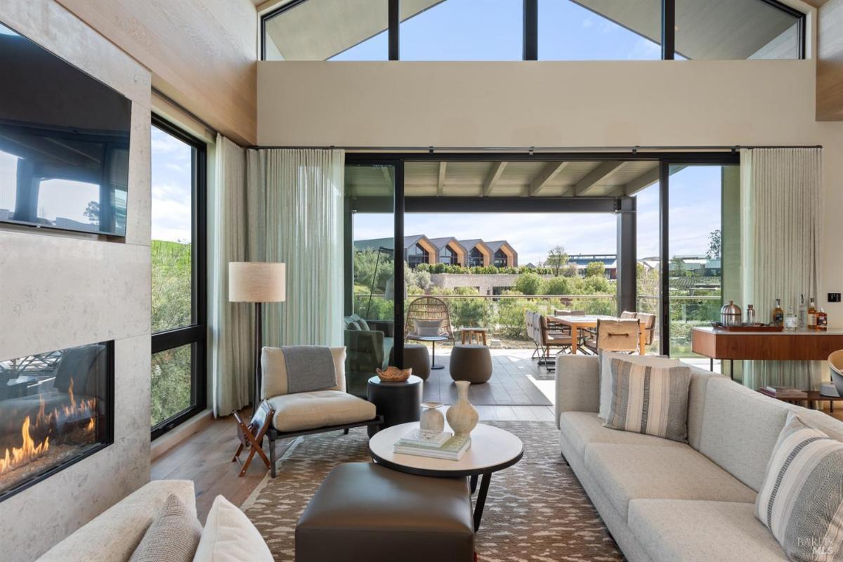 A living area with a fireplace and glass doors leading to an outdoor balcony.