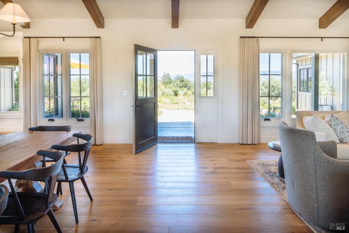 Entryway with an open door and wood floors.