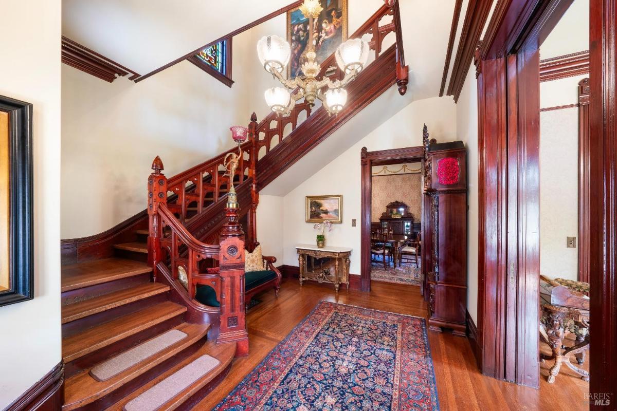 Wooden staircase and entryway with intricate railing design.