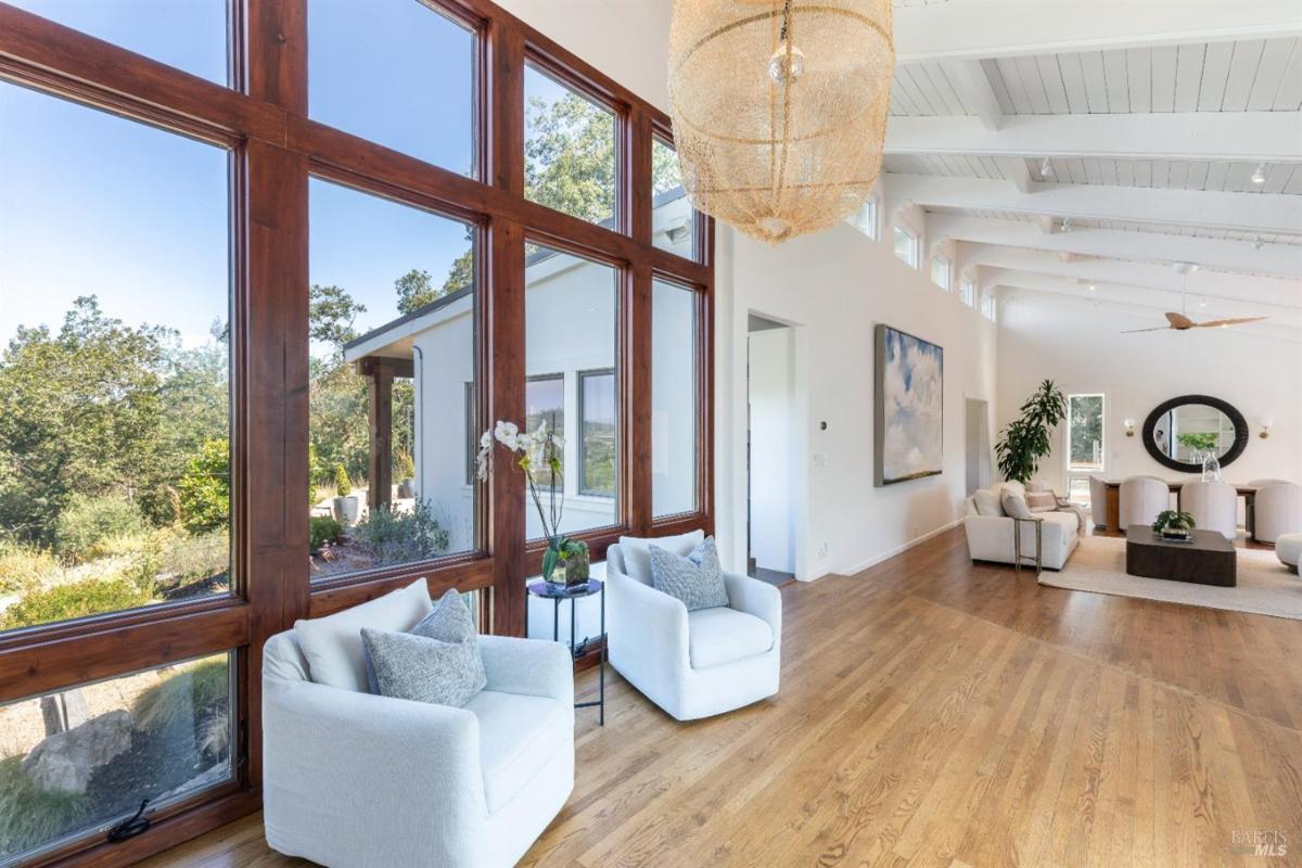 A seating area with large windows overlooking the garden.